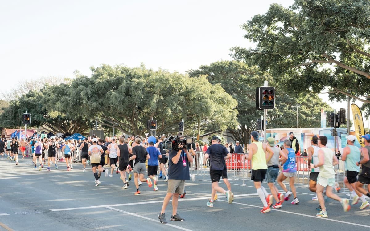 Largada de uma corrida de rua em avenida arborizada